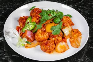 Chicken Chili Momo (Dumplings) on a white plate.